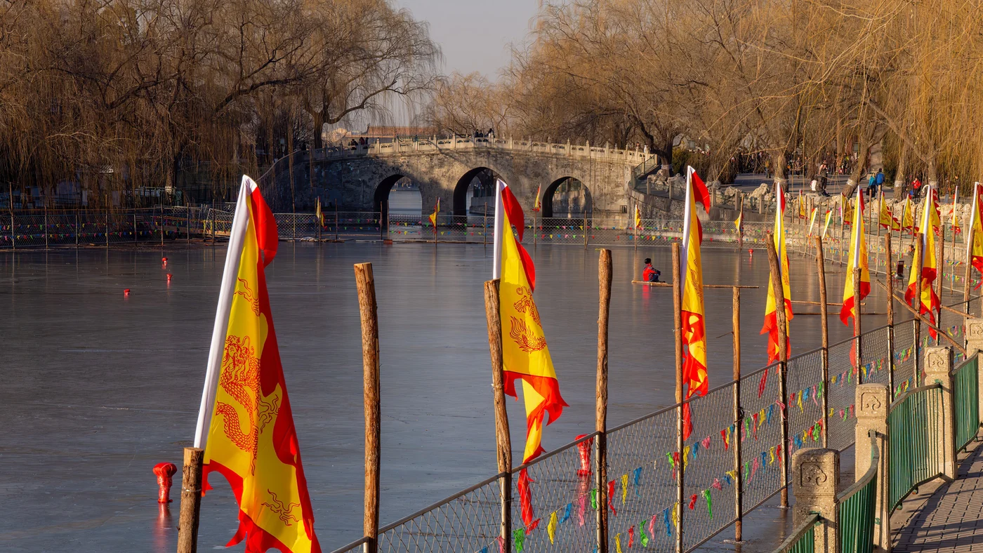 Colorful flags beside the lake and bridge in Beijing Beihai Park