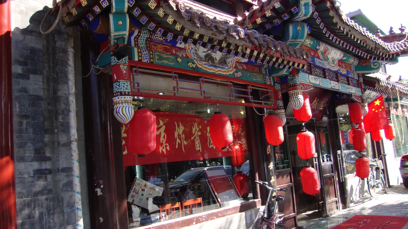 Colorful traditional eaves and red lanterns along a Beijing hutong