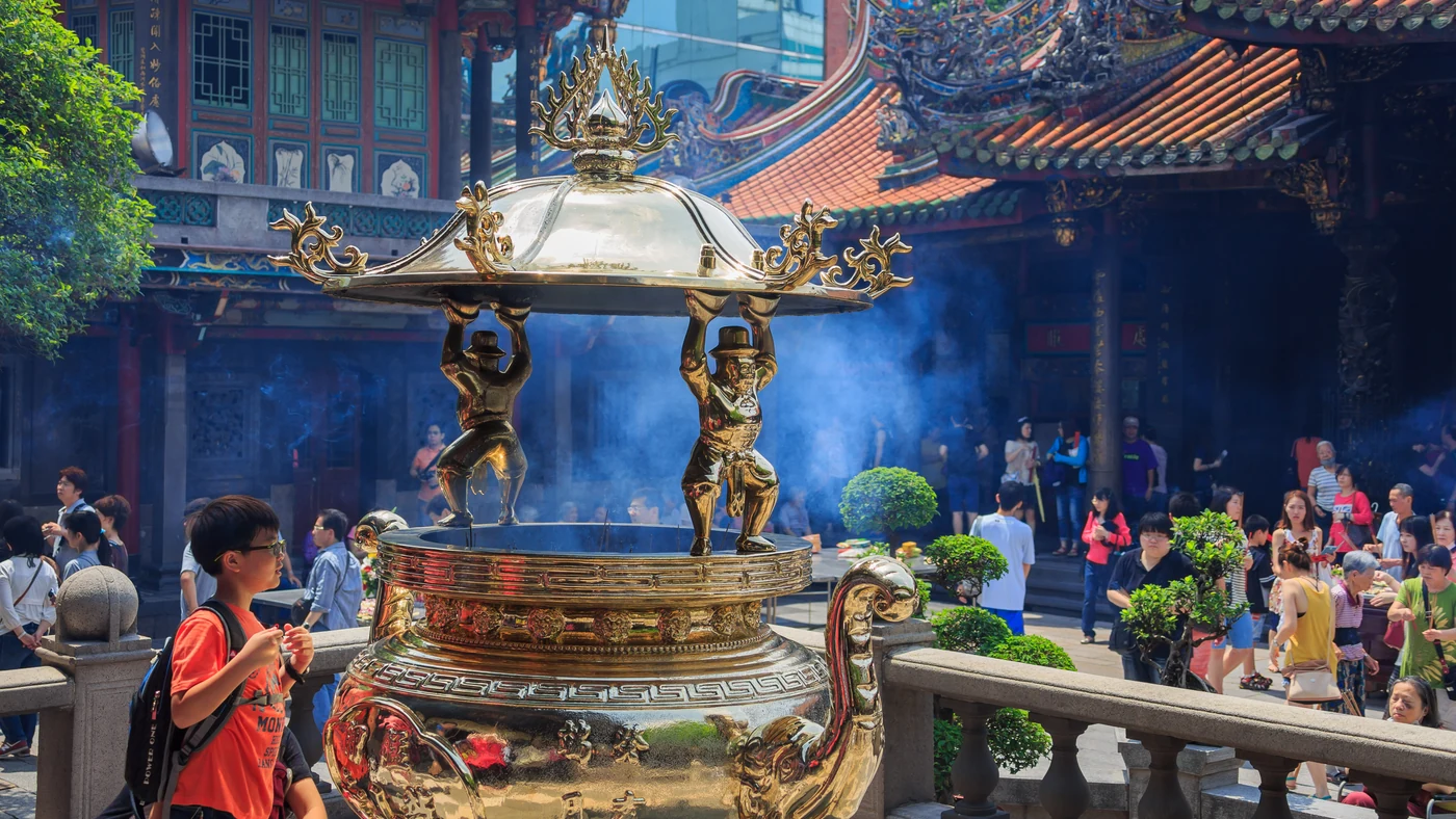 Incense drifting above a bronze burner at Longshan Temple in Taipei